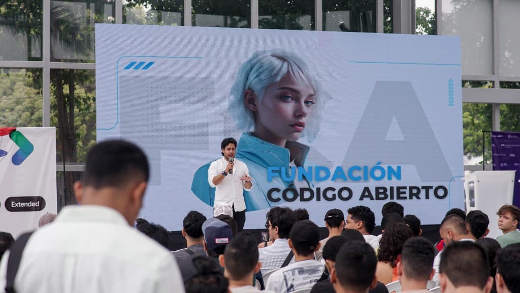 Charla ante una audiencia frente a una pantalla de la Fundación Código Abierto.